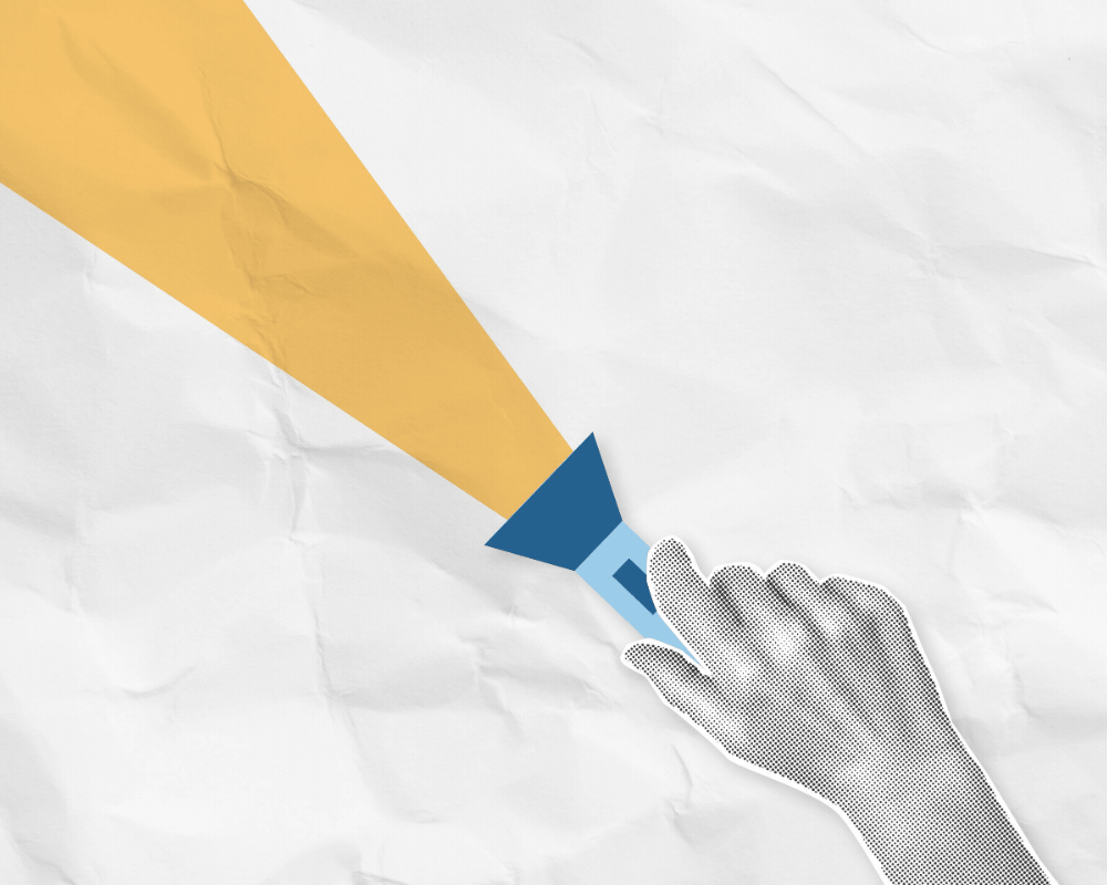 Trade Shows Are Back in the Spotlight Hand holding a flashlight highlighting renewed focus on trade shows.