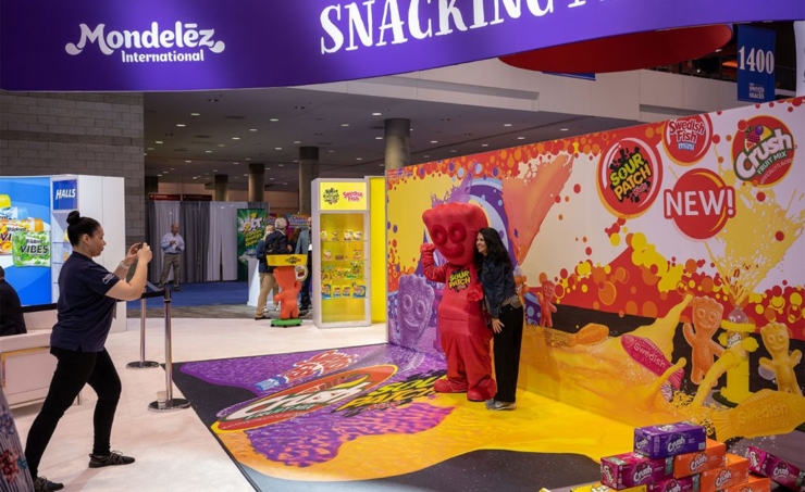 Woman demonstrating touch screen in Mondelez booth by Derse